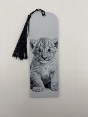 3D printed monochrome lion cub bookmark with tassel on white background