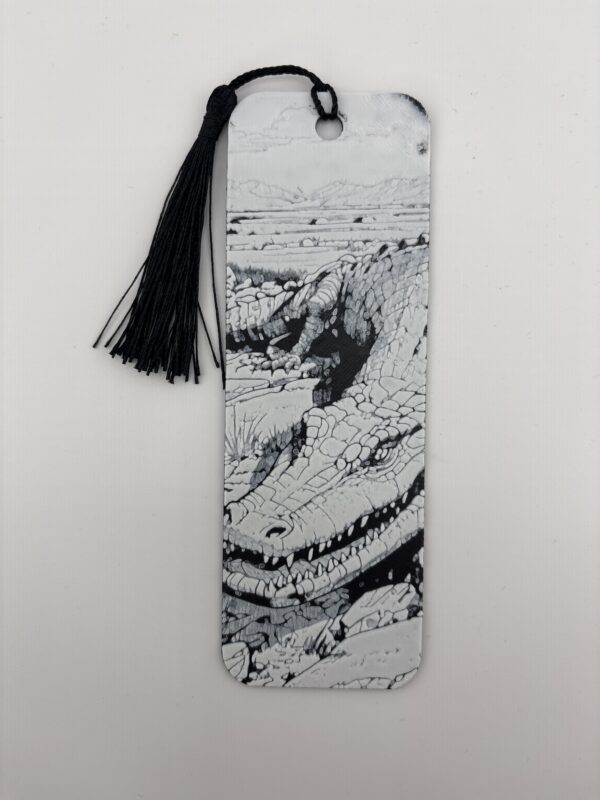3D printed monochrome crocodile bookmark with black tassel on white background