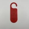 Back of red 3D printed door hanger showing reversed design