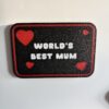 3D printed World’s Best Mum fridge magnet with red hearts and black background