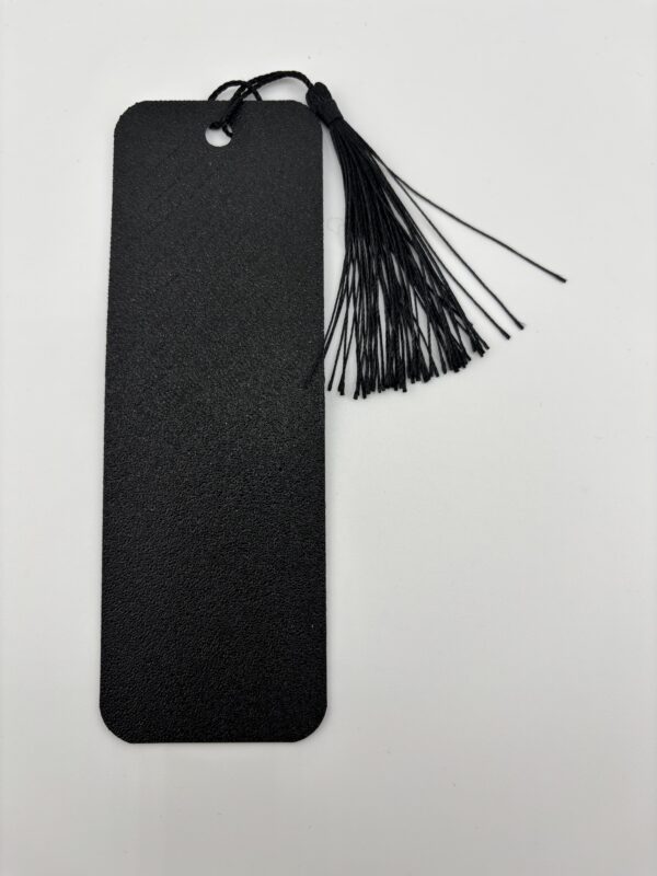 Back side of 3D printed PLA bookmark with textured black finish and attached tassel