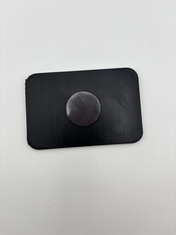 Back of 3D printed fridge magnet showing strong round magnet backing Back of 3D printed fridge magnet showing strong round magnet backing